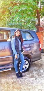 Portrait of smiling young woman standing by car