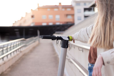 Close up view of unrecognizable woman holding an electric scooter handle. eco friendly energy