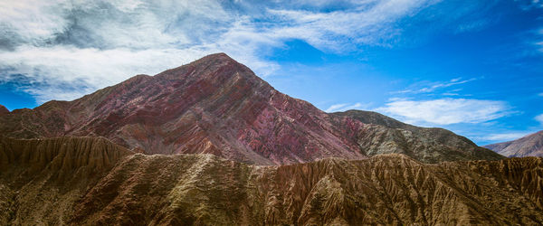 Scenic view of mountain range against cloudy sky