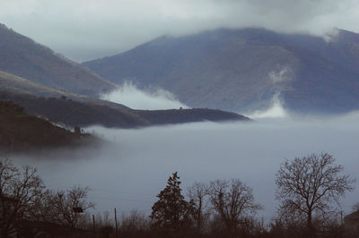 Scenic view of mist and mountains in a valley