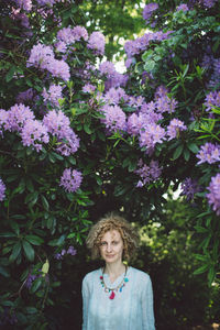 Portrait of woman against purple flowering plants