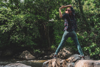 Man on rocks by trees in forest