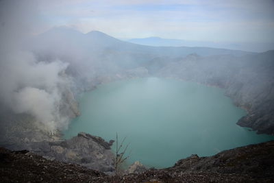 Smoke emitting from volcanic mountain against sky