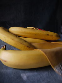 Close-up of a yellow bunch of bananas on a table with blue grey velvet and yellow silj