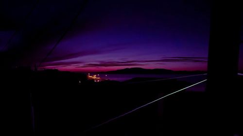 Silhouette city against sky at night