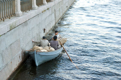 People rowing boat on shore