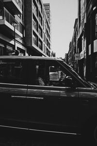 Cars on street amidst buildings in city