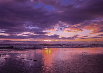 Scenic view of sea against dramatic sky during sunset