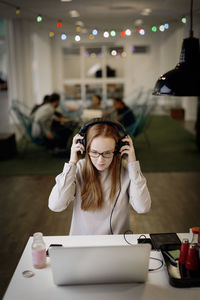 Woman using phone while sitting on table