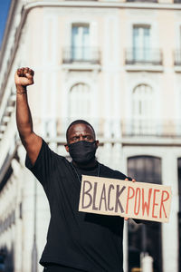 Portrait of man standing by building in city