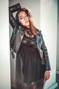 Young woman standing against wall