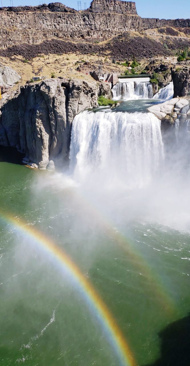 rainbow, waterfall, scenics - nature, water, beauty in nature, environment, nature, rock, travel destinations, landscape, travel, land, body of water, mountain, water feature, tourism, no people, non-urban scene, cliff, motion, sky, multi colored, outdoors, rock formation, idyllic, river, canyon, day, tranquil scene, plant, tranquility