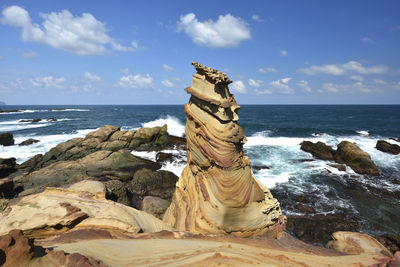 Scenic view of rocks on beach against sky