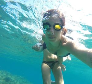 Portrait of young woman swimming in sea