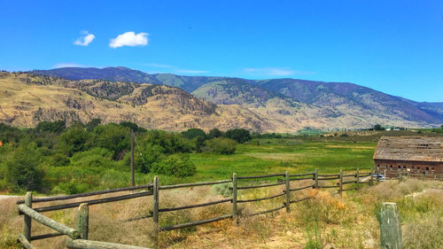 Scenic view of landscape and mountains against blue sky