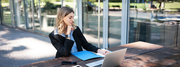 Side view of young woman using mobile phone