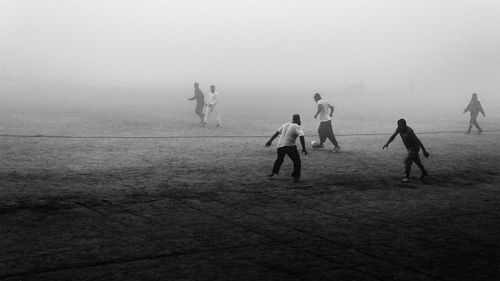 High angle view of people playing soccer in fog