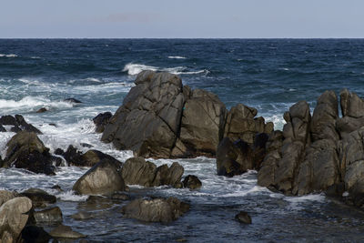 Rocks on beach against sky