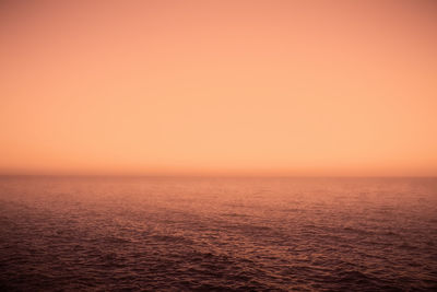 Scenic view of sea against orange sky