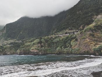 Scenic view of sea and mountains against sky