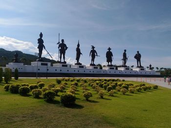 Statue in park against cloudy sky