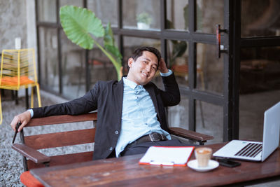 Portrait of young man using laptop at table