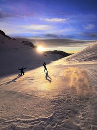 Man walking on snowcapped mountain against sky