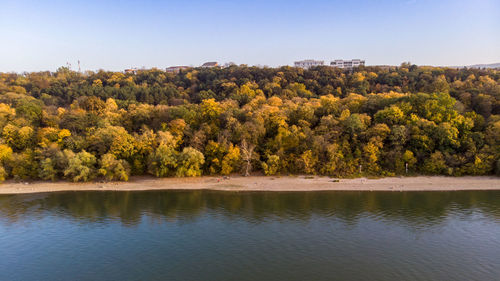 Scenic view of lake by trees against clear sky