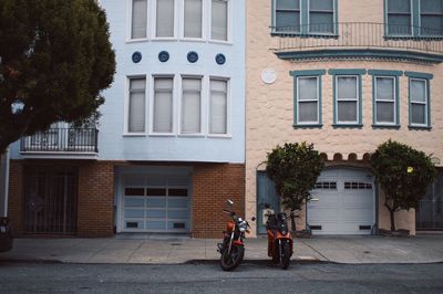 Motorcycles parked on street against buildings