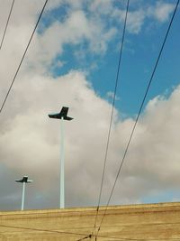 Low angle view of power lines against sky