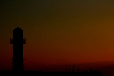 Silhouette of communications tower at night