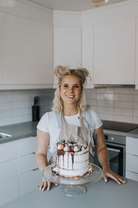 Woman in kitchen with cake