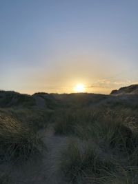 Scenic view of land against sky during sunset