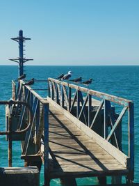 Pier over sea against clear sky