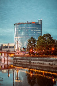 Reflection of buildings in lake against sky