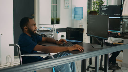 Side view of man using laptop at home