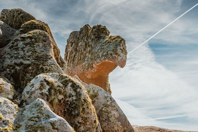 Low angle view of rock formation in sea against sky