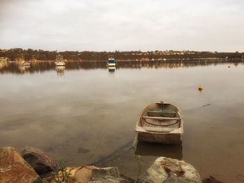 Boat moored in lake against sky