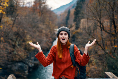 Young woman standing by tree during winter