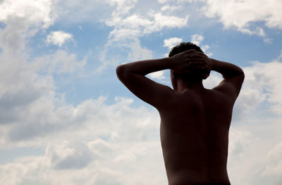 Low angle view of woman standing against sky