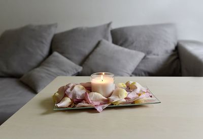 Close-up of burning candles on table at home