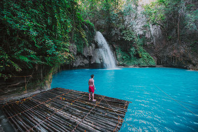 Man looking waterfall in forest