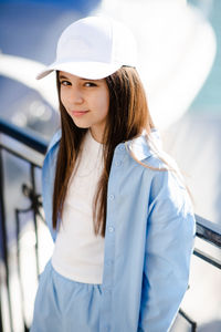 Portrait of young woman wearing hat standing outdoors