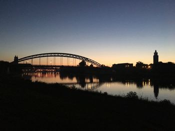 Silhouette of bridge over river against sky during sunset