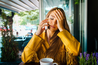 Young woman talking over smart phone in cafe