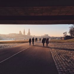 Rear view of silhouette people on bridge