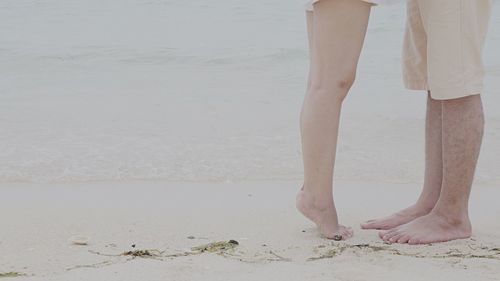 Low section of woman standing on beach