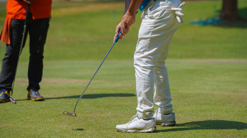 Low section of man playing golf