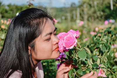 Close-up of woman with pink flower