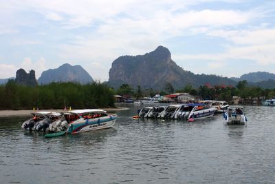 Boats moored in lake against sky